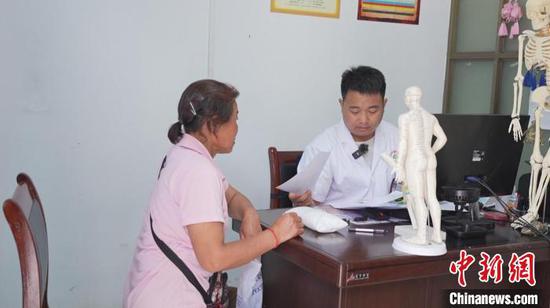 图为刘方文在门诊看病坐诊。杨承涛 摄