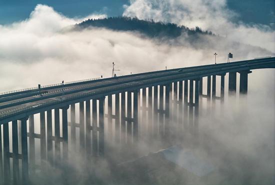 Bridge emerges through sea of clouds in Sichuan